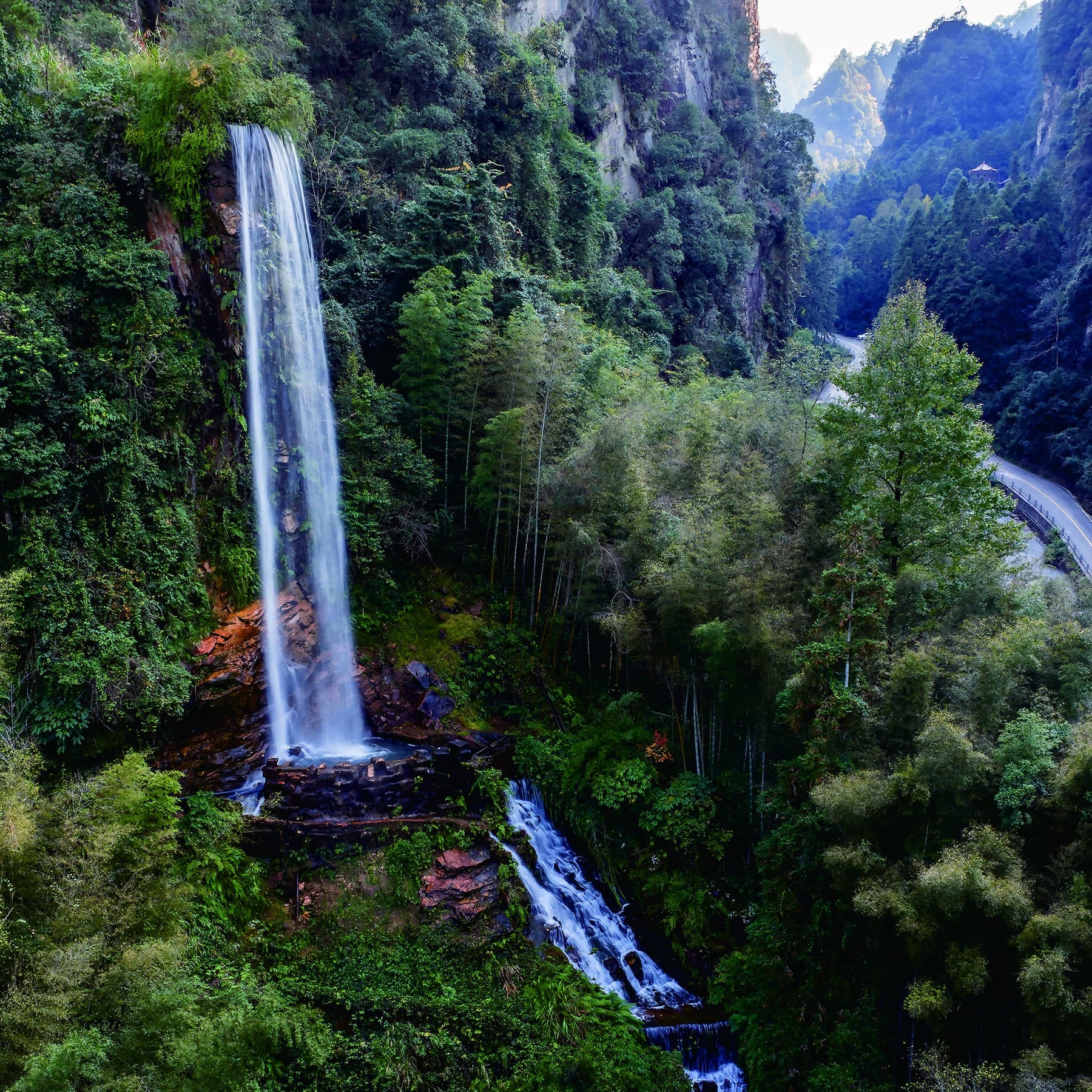 Official photograph of Baofeng Waterfall descending through a forested gorge