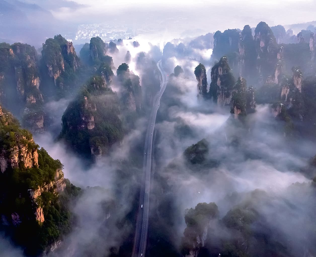 Road through misty sandstone towers in Thousand-Foot Gorge in the official Tour Guide Manual
