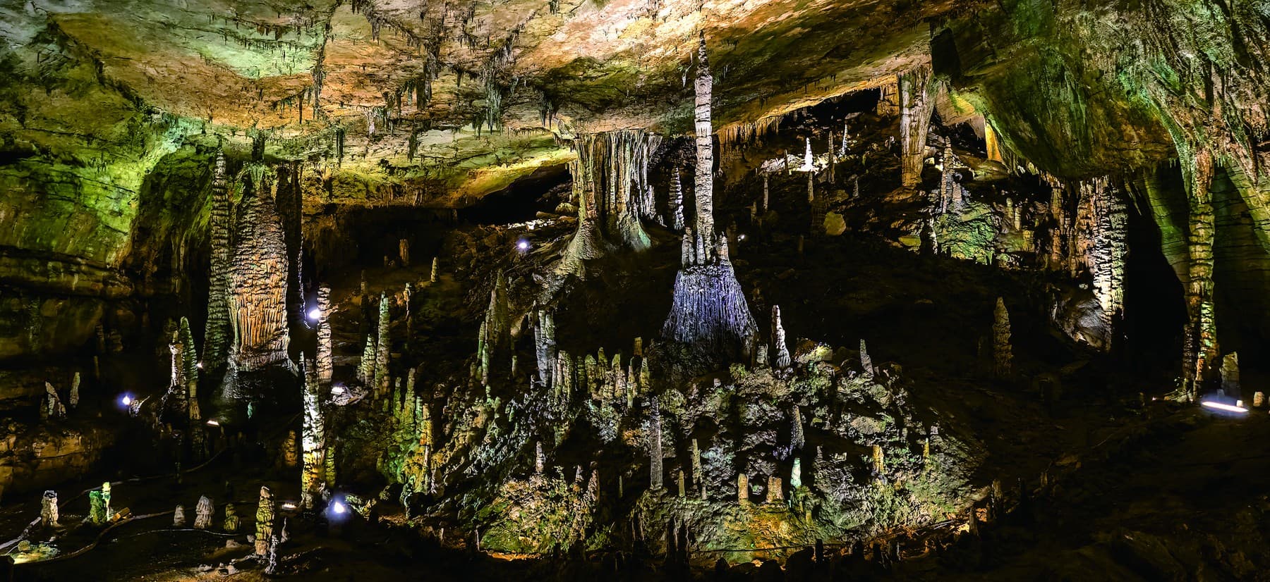 Broad illuminated chamber filled with limestone formations