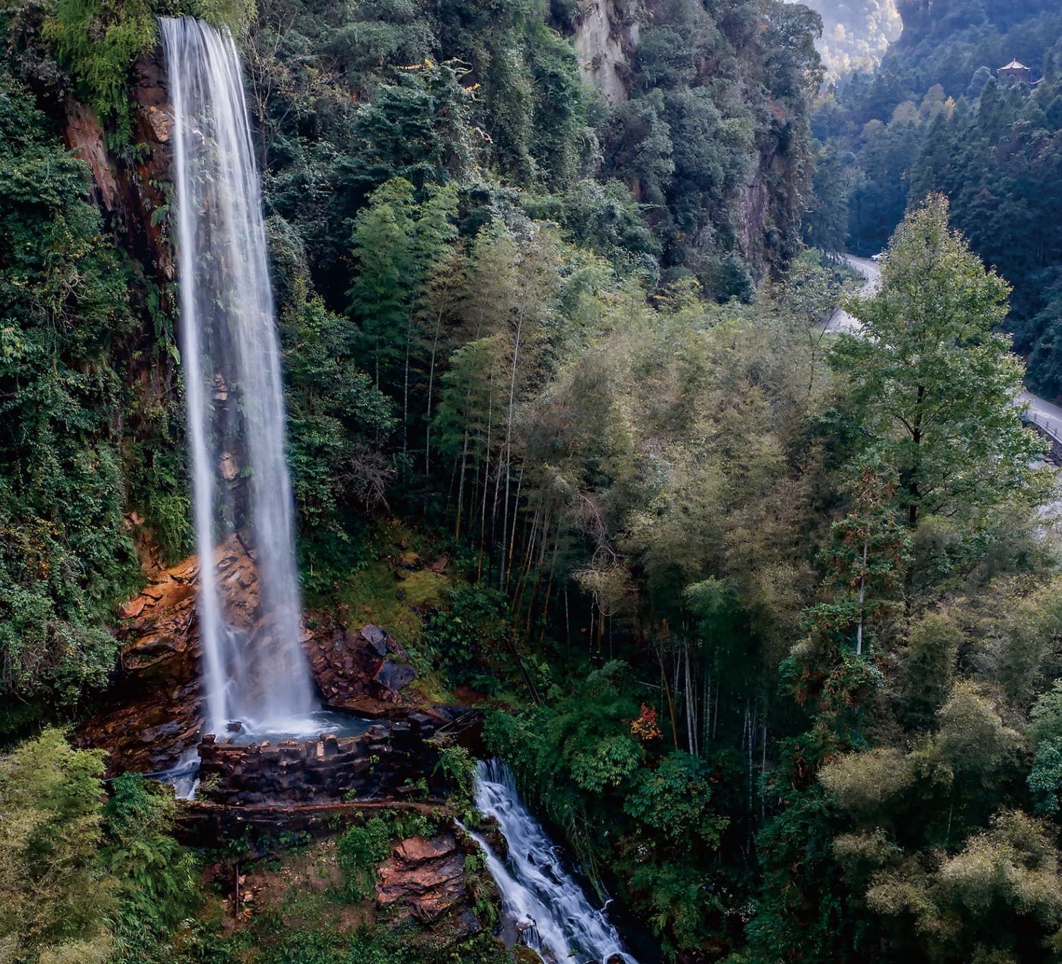 Forest waterfall and route landscape documented in the official Tour Guide Manual